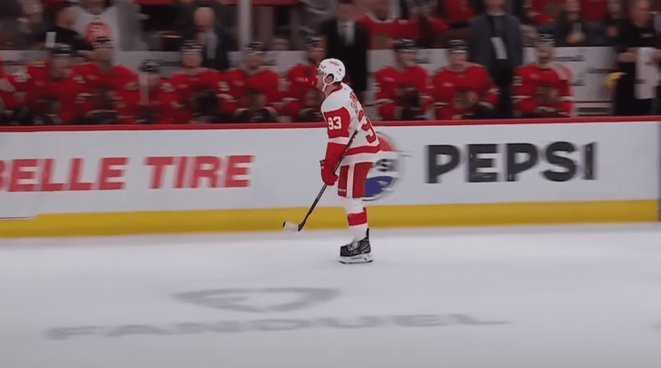 Alex DeBrincat #93, of the Detroit Red Wings scores with 1.5 seconds in the first period against the Chicago Blackhawks